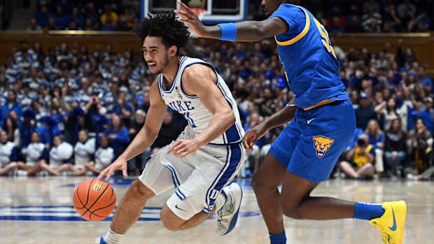 Duke Blue Devils guard Jared McCain dribbles past Pittsburgh Panthers defenders.